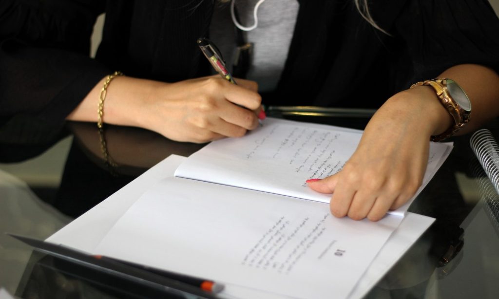 a person writing on a piece of paper